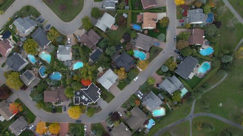 Fall in Montreal, Quebec, Canada, top-down aerial view of residential neighbourhood showing family homes and colourful maple trees in Autumn season.