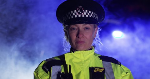 4K Closeup portrait of British policewoman looking at camera with serious expression