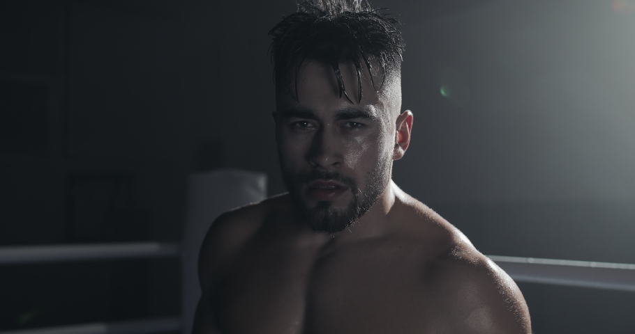 Portrait of angry male boxer standing on the boxing ring and looking intensely at the camera. Royalty-Free Stock Footage #1035726620