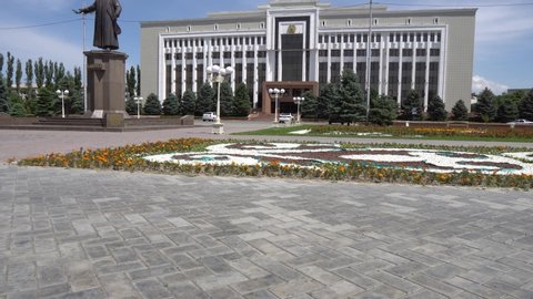 Taraz Regional Akimat City Hall with Waving Kazakh Flag at Background with Statue of Jambyl  Side View on a Sunny Blue Sky Day