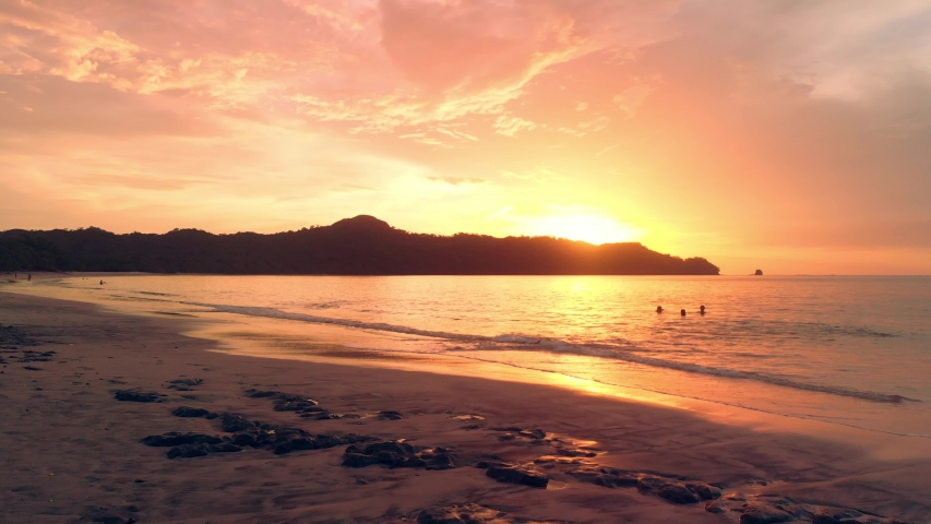 Drone flight forward into the sunset at Conchal beach, Costa Rica. 