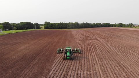 Drone view looking back towards tractor in field in Salem, IL, USA with copy space above