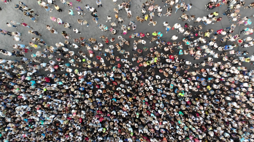 Aerial. People crowd on a city square. Mass gathering of many people in one place. Top view from drone fly.  Royalty-Free Stock Footage #1035753830