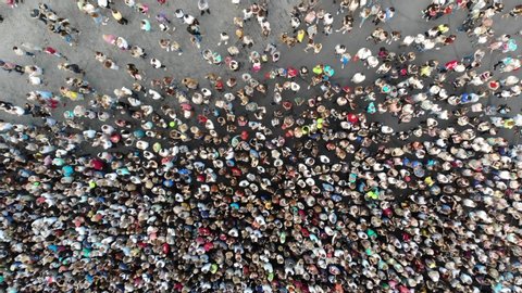 Aerial. People crowd on a city square. Mass gathering of many people in one place. Top view from drone fly. 