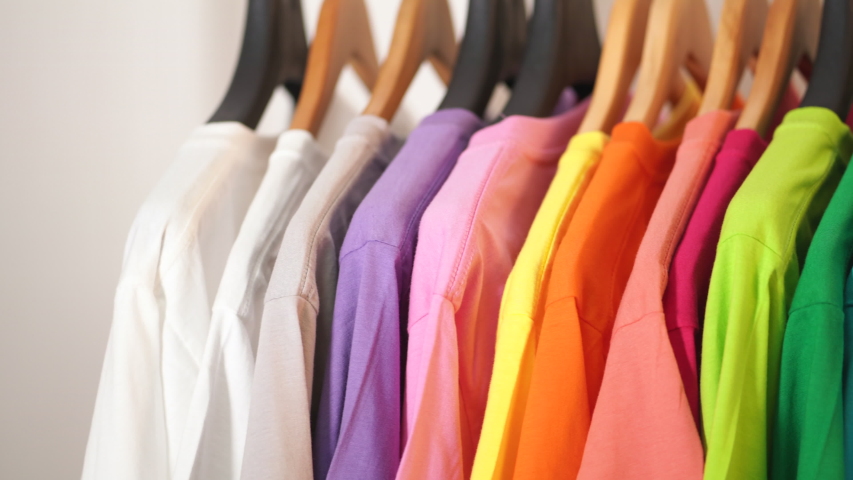 Close up of Colorful t-shirts on hangers, apparel background Royalty-Free Stock Footage #1035757619