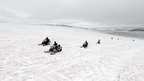 Aerial view of snowmobile tour driving in snowy hills.Arctic expedition atmosphere, north pole,winter landscape of Vatnajokull Glacier Iceland. Extreme sport,adventure and travel destination concept.