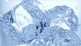 Water with ice. Pouring Water with Ice and bubbles in a glass. Slow motion 240 fps. Close up food and beverage background. Stock full HD video footage 1920x1080p. 