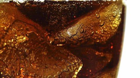 Cola with ice cubes background. Slow motion 240 fps. Cola with Ice and bubbles in a glass. Soda closeup. Food background. Cold beverage. Stock full HD video footage 1920x1080p, 1080. 