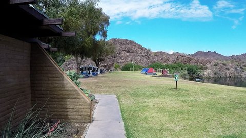 Parker, AZ / USA - June 1, 2017: Shot of a camping and picnic area at River Island State Park. Clip reveals a designated grassy camp site with nearby facilities at edge of Colorado River.