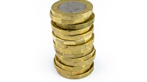 Stack of british one pound coins decreasing one by one. Concept for pound inflation or loosing the savings. Isolated on white, stop motion video.