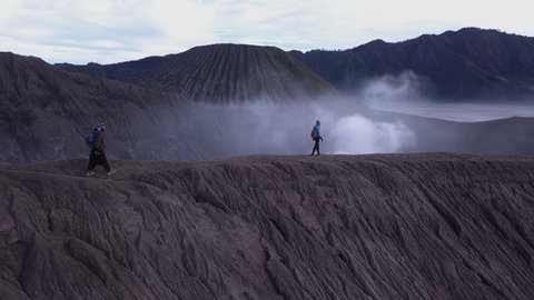 AERIAL: A hikers walks at the edge of Bromo volcano in Java island, Indonesia