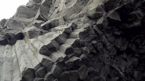 Close up detailed shot of famous basalt rocks at the Black Beach in Vik, Iceland. Volcanic geological formation. Travel destination, geology, beauty in nature and tourism concept.