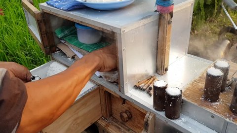 Making putu cake, a traditional snack from Indonesia made from rice and coconut, cooked with bamboo molds and steamed. The process of entering the ingredient into a bamboo mold.