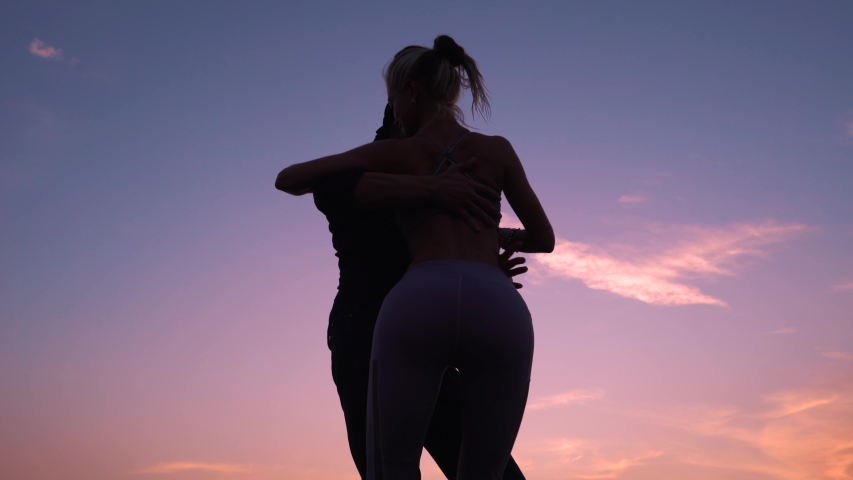 Man and woman dance in the evening at sunset.