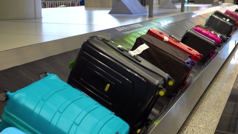 Various suitcases moving on the luggage conveyor belt at arrival area in the passenger terminal at Hong Kong International airport