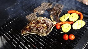 Dallas Steak tenderloin T-bone Steak Ribeye chicken wings mixed meat being cooked on the grill vegetables corn pepper tomatoes preparing a wonderful luxury grilled meats different alternative angles.