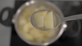 sliced boiled potatoes in a tablespoon on a background of a potato pan. 4k. 4k video
