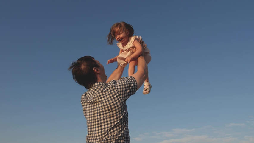 Father and little child play, laugh and hug together. Dad throws up a happy daughter in blue sky. appy family travels. Baby in the arms of the parent. Dad day off. The concept of a happy family Royalty-Free Stock Footage #1035809840