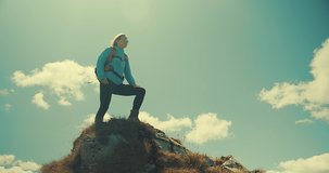 Woman tourist traveler walking on the top of mountain in summer sunny day under sun light. Beautiful mountains landscape view. 4K slow motion video