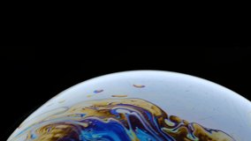 Macro shot of a soap bubble creates a colorful and black background