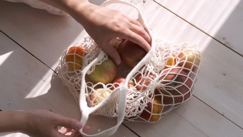 Zero waste home and eco bag. Eco Shopping. Reusable grocery bags with fruits and vegetables on the kitchen on wooden table. Slow motion - Βίντεο στοκ