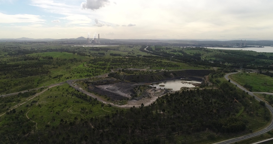 Vast industrial area in Hunter Valley New England region of Australia with black coal mines and fossil fuels power plants generating electricity.
