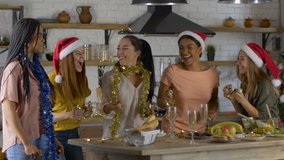 5 girlfriends celebrate the New Year Christmas and toss up confetti. cozy dining room in a large house. Slow motion