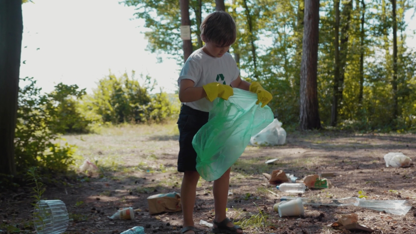 Close up voluteers activists child in gloves tidying up rubbish in park or forest save environment stop plastic pollution bag bottle recycle ecology garbage nature altruism care clean slow motion Royalty-Free Stock Footage #1035821453