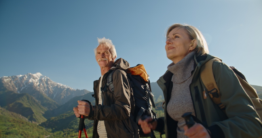 Mature caucasian couple on vacation, having a hike in spring mountains, spending time together after retirement together travelling - tourism, pension concept 4k Royalty-Free Stock Footage #1035824636
