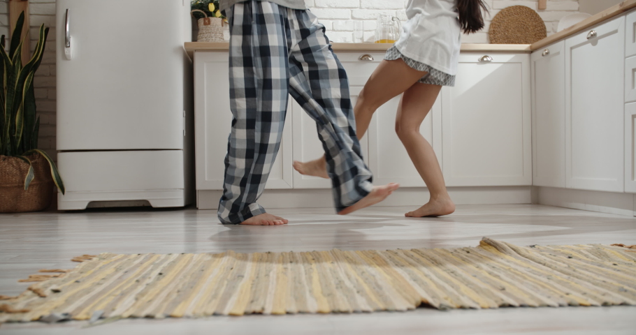 Low angle shot of unrecognizable couple crazily dancing in kitchen during their pajamas party - recreational pursuit 4k Royalty-Free Stock Footage #1035824723