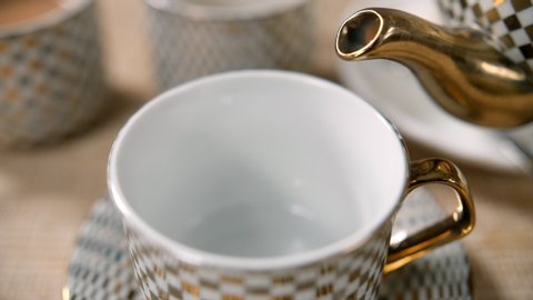 A close slow motion shot of pouring darjeeling tea in a cup.