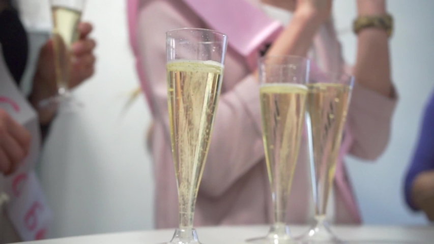 Close-up of champagne glasses amid a lively party suggests a celebratory atmosphere, marking special occasions, such as weddings, anniversaries, or festive events. Shared moments of happiness closeup. Royalty-Free Stock Footage #1035830741