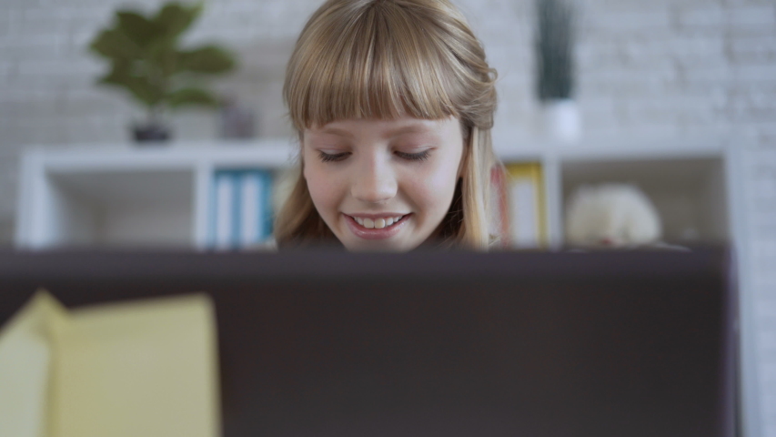 cute 10 years old girl is playing a computer game intently 4K