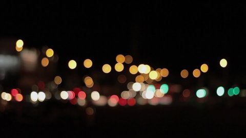 Lights of the night city background. Defocus headlights of moving cars urban traffic. Abstract bright blured colored bokeh.