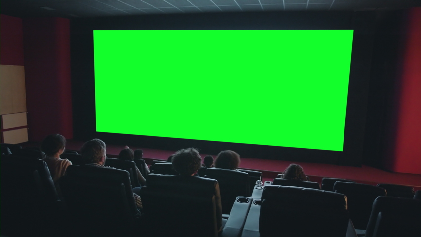People audience are looking at big green chroma key screen in cinema enjoying film indoors in dark room. Entertainment, leisure and modern technology aoncept. | Shutterstock HD Video #1035857753