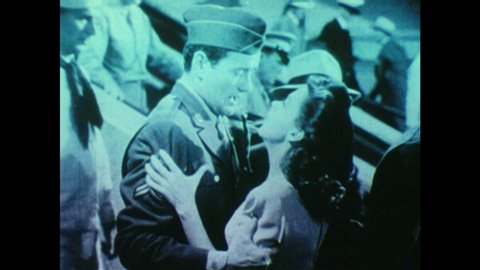 1940s: UNITED STATES: soldier kisses lady on train platform. Soldier asks lady to marry him.