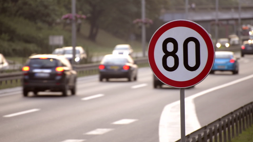 Cars moving along the highway next to a 80km/h speed limit sign Royalty-Free Stock Footage #1035861269