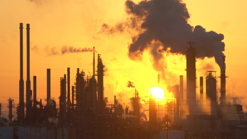 pictorial refinery pipe silhouettes with black smoke clouds. smoking fatory on orange sunrise