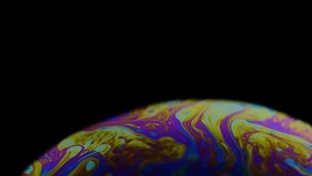 Multicolored rainbow colors of a single soap bubble that looks like a fantasy planet isolated against a black background - Powered by Shutterstock - Get 15% off with code: PIKWIZARD15