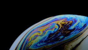 Multicolored rainbow colors of a single soap bubble that looks like a fantasy planet isolated against a black background - Powered by Shutterstock - Get 15% off with code: PIKWIZARD15