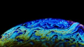 Multicolored rainbow colors of a single soap bubble that looks like a fantasy planet isolated against a black background - Powered by Shutterstock - Get 15% off with code: PIKWIZARD15