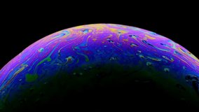 Multicolored rainbow colors of a single soap bubble that looks like a fantasy planet isolated against a black background - Powered by Shutterstock - Get 15% off with code: PIKWIZARD15