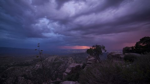 Time lapse of thunderstorms and lightning over a city at dusk