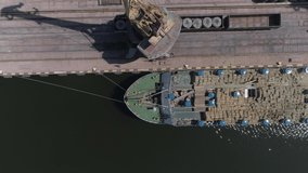 Cattle, cows loading from trucks into the cargo ship at the docks, industrial area. Aerial footage
