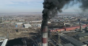 Aerial footage of coal-fired plant smokestack. Black smoke cloud is coming from chimney. 4K
