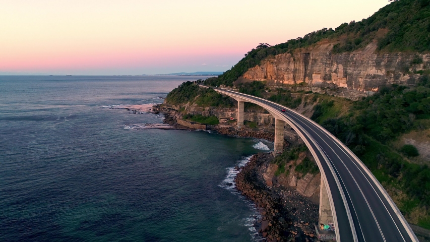Aerial Drone Video of Cars Driving over Sea Cliff Bridge, Illawarra, Wollongong, NSW, Australia at Sunrise Royalty-Free Stock Footage #1035892001