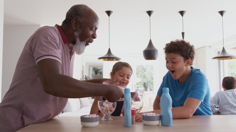 Grandfather Serving Ice Cream To Grandchildren In Kitchen