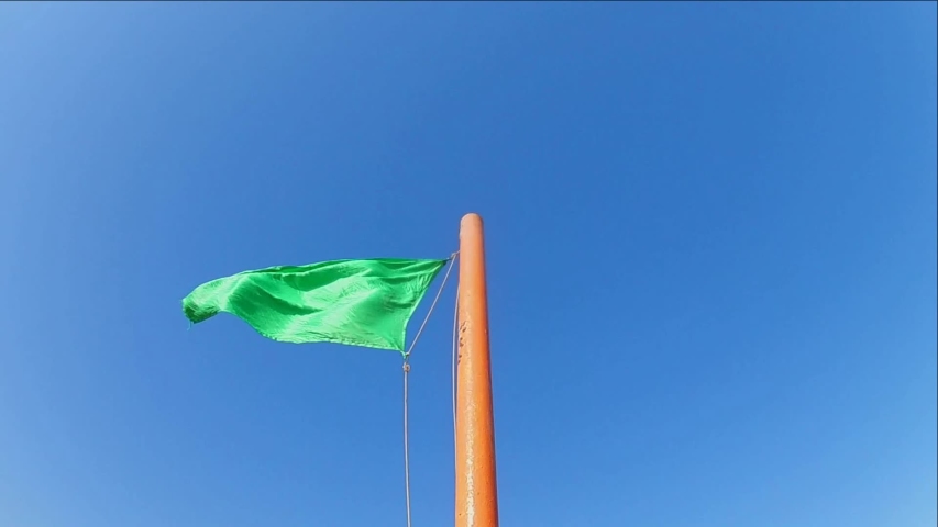 green safe flag waving on flagpole: стоковое видео (без лицензионных платеж...