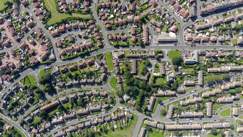 Aerial footage of the British town of Middleton in Leeds West Yorkshire showing typical suburban housing estates with rows of houses, taken on a bright sunny day using a drone. 