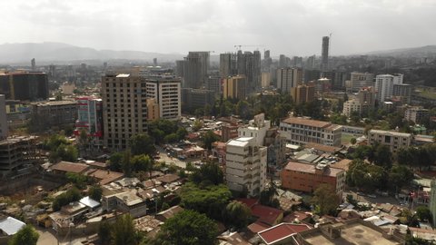 ADDIS ABABA, ETHIOPIA – MARCH 2019: Ascending drone shot flying towards modern Addis Ababa skyline with commercial office towers and construction sites